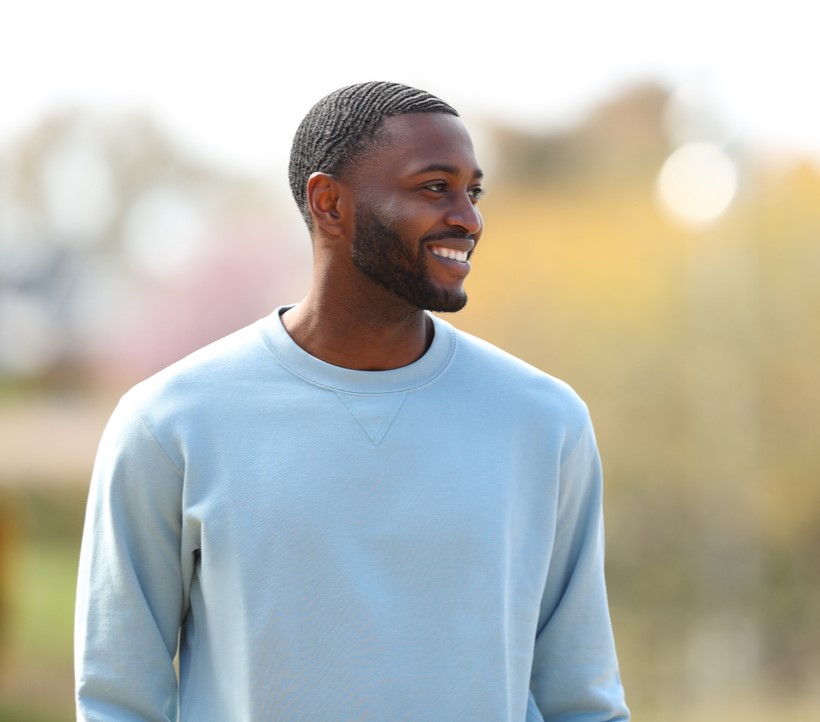 Happy black man walking looking at side