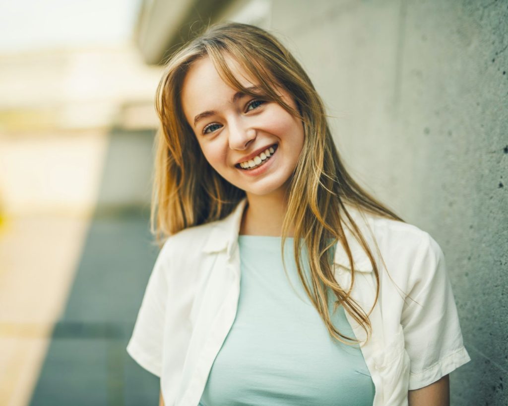 A young woman on street, generation z girl posing outdoor backlit with sunlight, portrait.