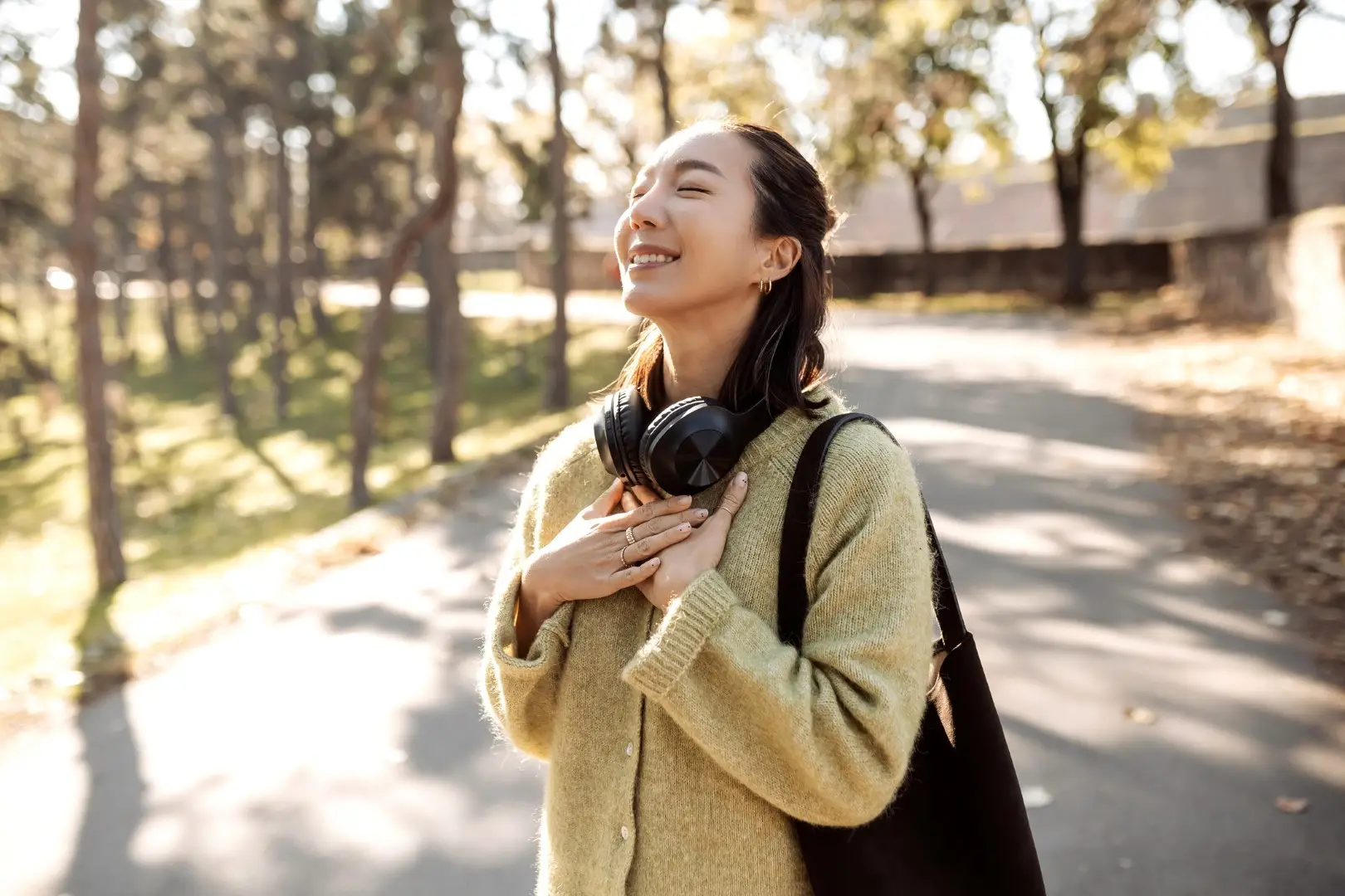 Beautiful Asian woman walking outdoor at the perfect sunny Autumn day