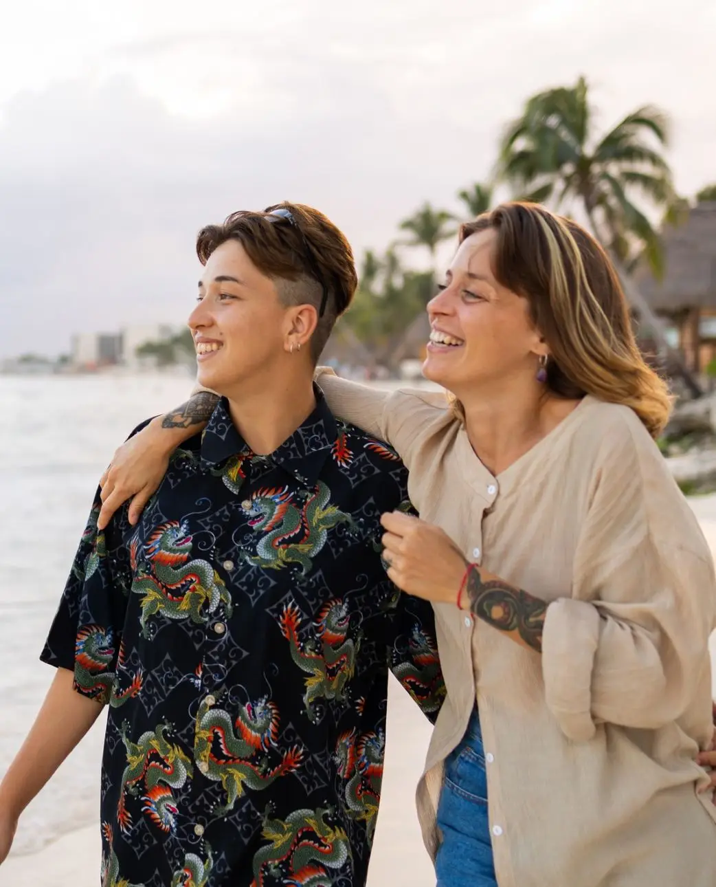 Same-sex couple is walking on the beach, they are enjoying the sunset