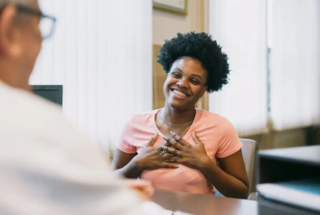 Female patient gesturing while talking to doctor stock photo